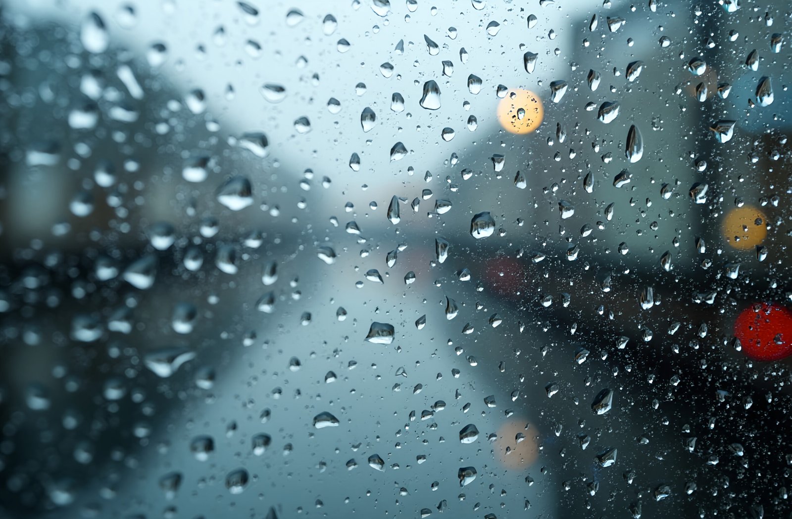 Blurred glass window surface covered with water droplets from rain