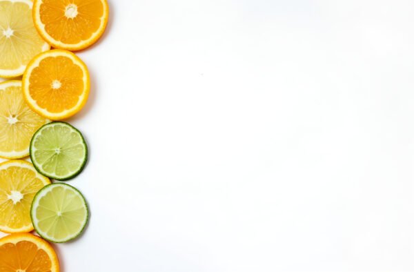 sliced lemons, limes, and oranges in one corner, leaving the rest of the white background empty