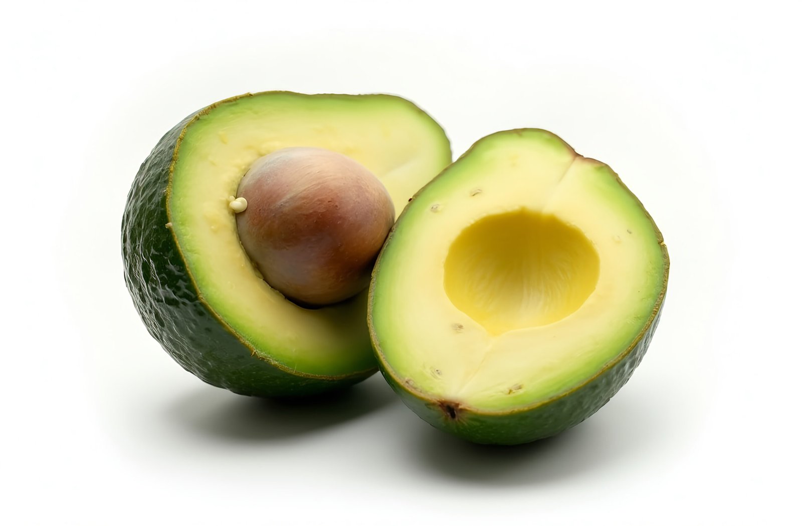 A ripe avocado cut in half, showing its creamy texture and large seed in the center, isolated on white background
