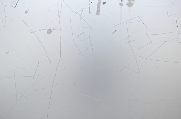 Close-up of scratched aluminum surface showing scuffs and brushed metal texture