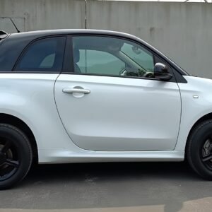 Small white hatchback car on a road—ideal for compact vehicle visuals, commuter car features, and auto design content