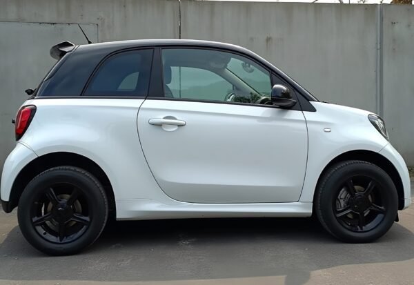 Sideview of a small hatchback white car in the street