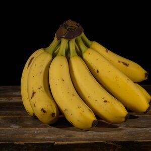 Bunch of golden ripe bananas sitting on rustic weathered wooden table surface in natural farm kitchen setting