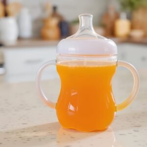 Transparent sippy cup close-up on white background—free image for baby-training, toddler-feeding or parenting visuals.