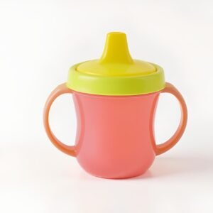 Photorealistic image of a colorful plastic sippy cup isolated on a white background