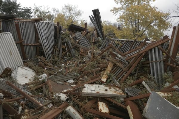 Photorealistic junkyard scene with broken rusted fences and crushed metal objects