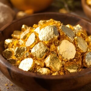 Unrefined raw gold nuggets in a wooden bowl with warm natural textures