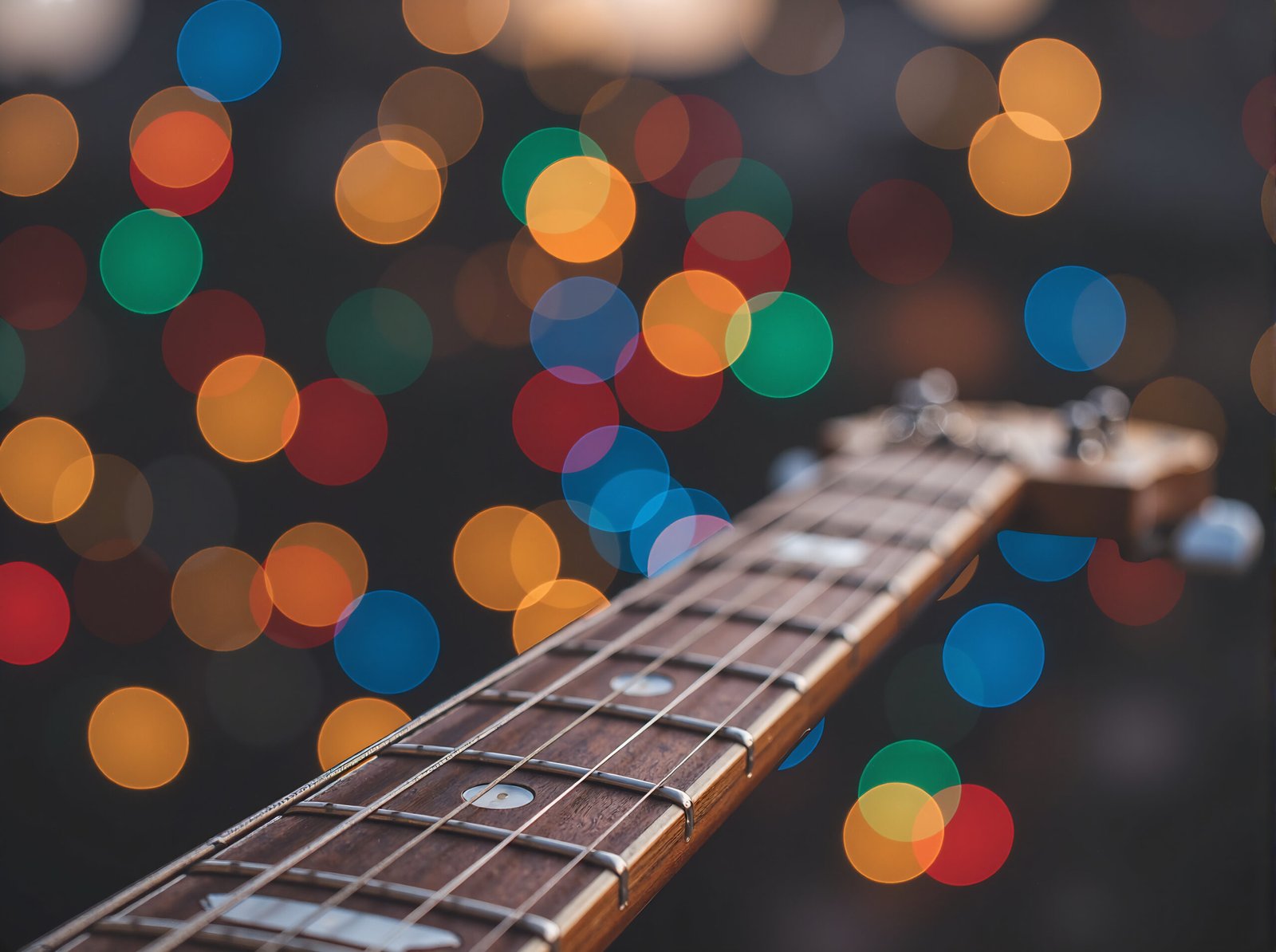 Guitar neck in sharp focus showing frets and strings detail for musical instrument photography