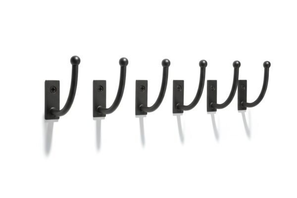 Black metal wall hooks row isolated on white background sharp shadows product style photography