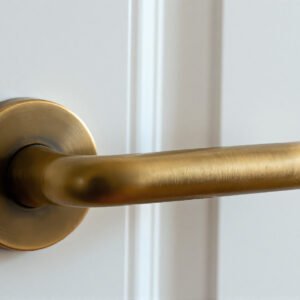 Brass door handle mounted horizontally on white door soft daylight