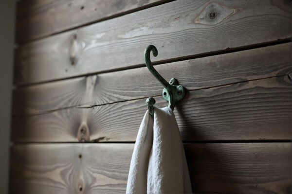 Clothes hook mounted on wooden wall detailed textures soft natural light