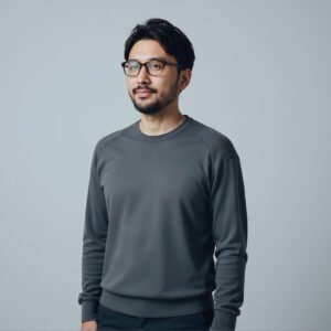 Studio portrait of a Japanese man with glasses minimalist gray backdrop calm expression
