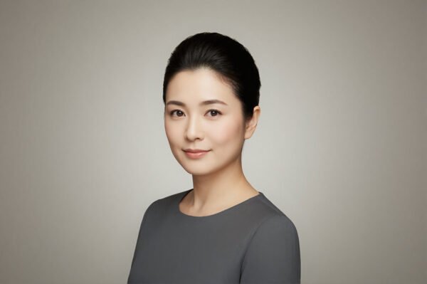 Studio portrait of a Japanese woman with neat bun hairstyle neutral backdrop natural expression balanced lighting