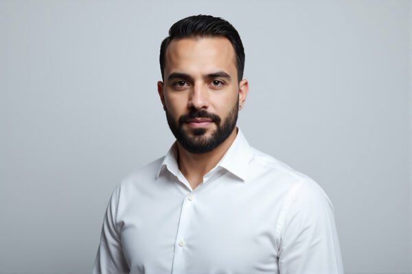 Studio portrait of a Middle Eastern man with trimmed beard white shirt even lighting clean backdrop