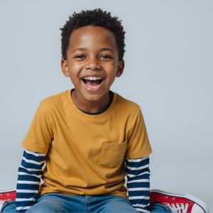 Studio portrait of an African boy smiling brightly softbox lighting light gray background casual outfit