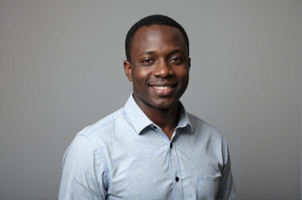 Studio portrait of an African man wearing casual shirt neutral gray background soft key lighting friendly expression