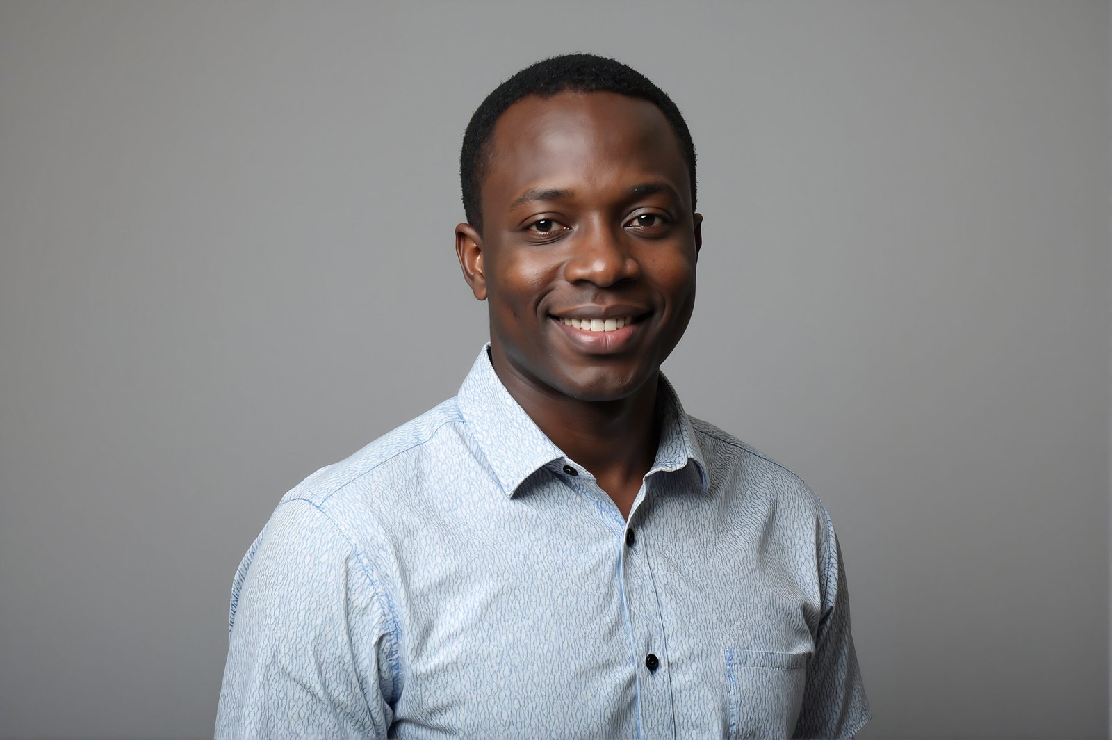 Studio portrait of an African man wearing casual shirt neutral gray background soft key lighting friendly expression
