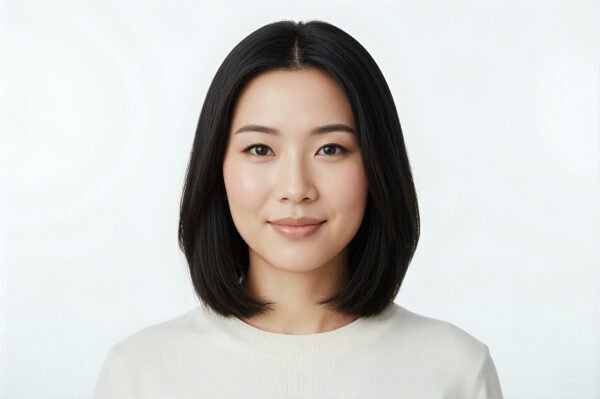 Studio portrait of an Asian woman with straight black hair clean white background subtle makeup calm expression