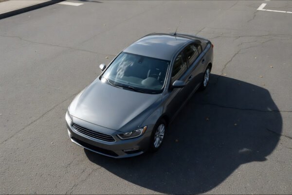 Top down view of generic sedan on asphalt realistic shadows no branding