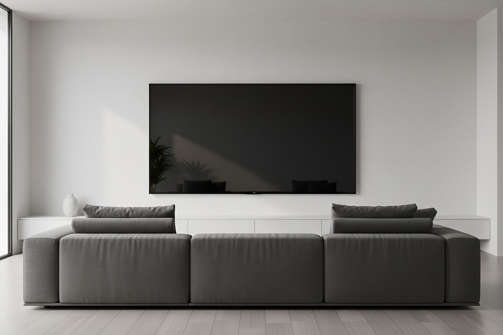 Wall mounted TV in minimalist room turned off reflective black screen no visible branding or manufacturer names or labels