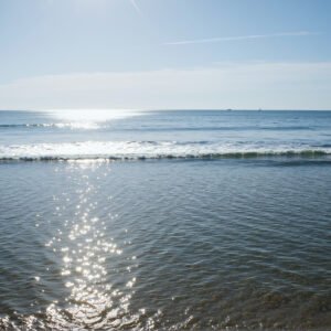 Wide ocean view with gentle waves and clear horizon bright daylight realistic water reflections