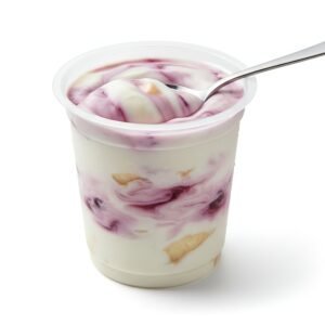 fruit yogurt in transparent cup with spoon creamy texture visible isolated on white clean product style photography