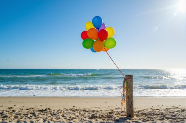 Download this colorful birthday balloons photo on sunny beach, perfect for party invitations, festive marketing visuals, and summer greeting designs.