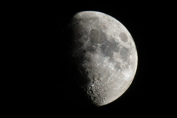 sharp telescopic view of a half moon with detailed surface texture black space background qLYgI0Hl upscaled